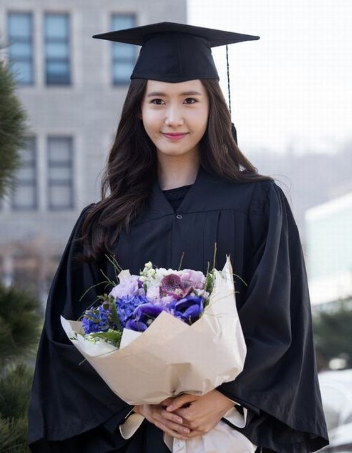 Hình ảnh nữ sinh tay cầm hoa trong trang phục tốt nghiệp