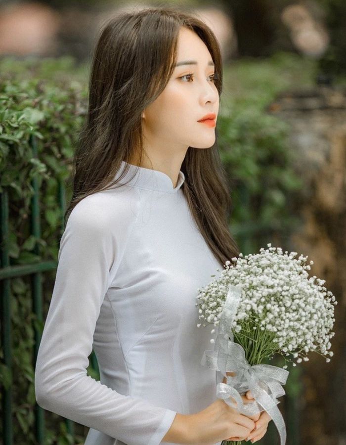 Trang phục áo dài trắng nổi bật kết hợp cùng bó hoa