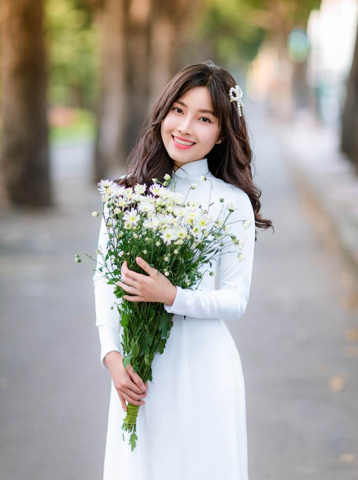 Nữ sinh xinh đẹp tạo dáng chụp ảnh với bó hoa